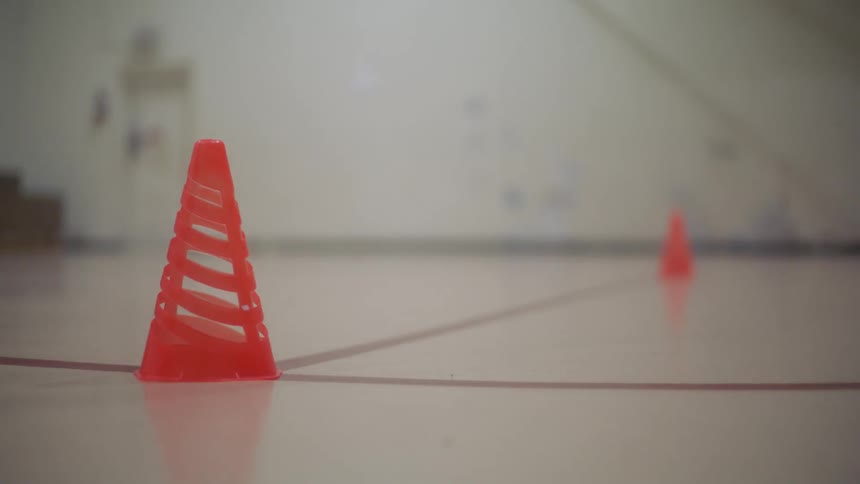 An athlete does agility drills on a basketball court