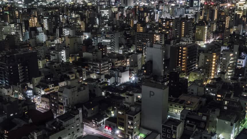 The city is brightly lit as cars travel at night