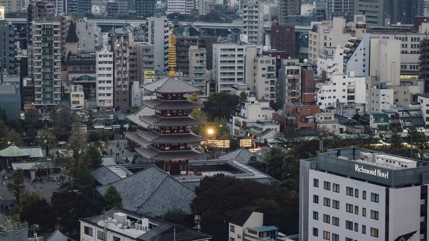 People are moving through an urban square containing a pagoda throughout the day