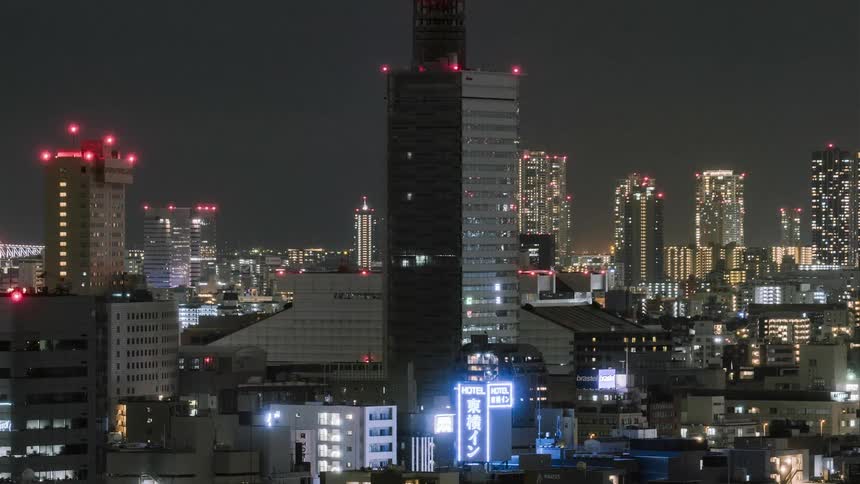 Quick moving lights of a helicopter shine over a large city at night