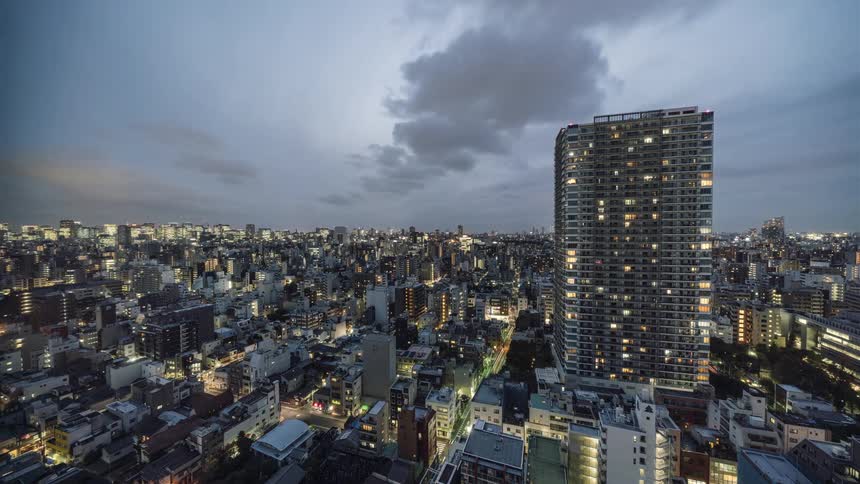 Clouds roll over a lit up city at night