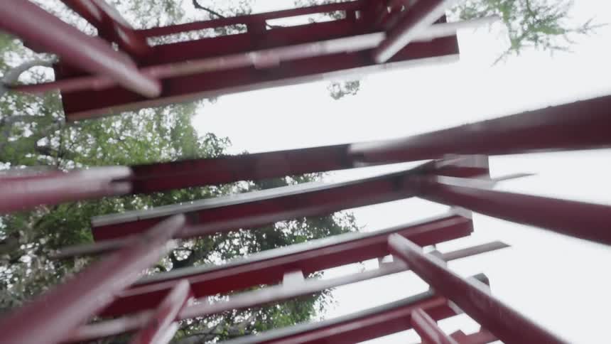 Red structure with trees over it on a sunny day