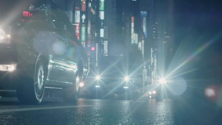 Traffic is crawling along a city street at night