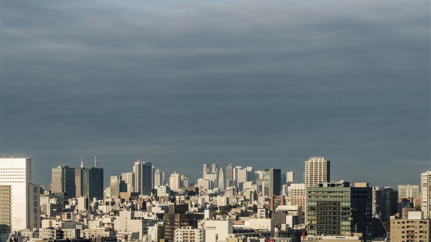 Clouds are passing over a city throughout the day