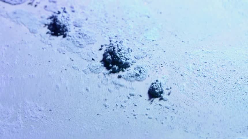 Colored powder clumps together and jumps as the surface vibrates