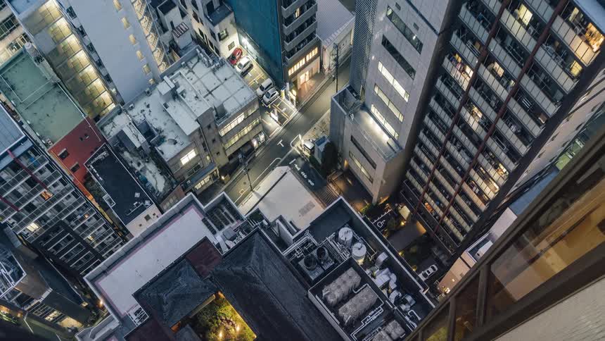 Traffic and pedestrians travel along a street in an urban area as time passes