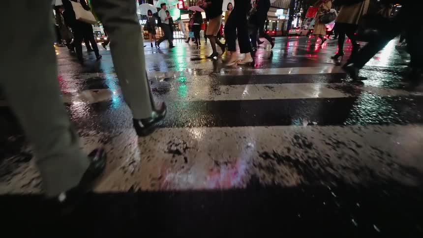 People cross an intersection of a city at night
