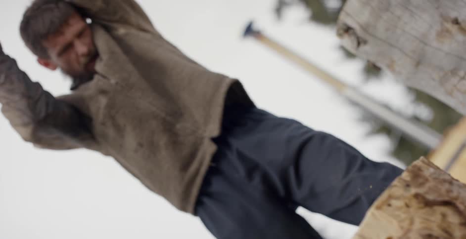 A man chops firewood with a hatchet
