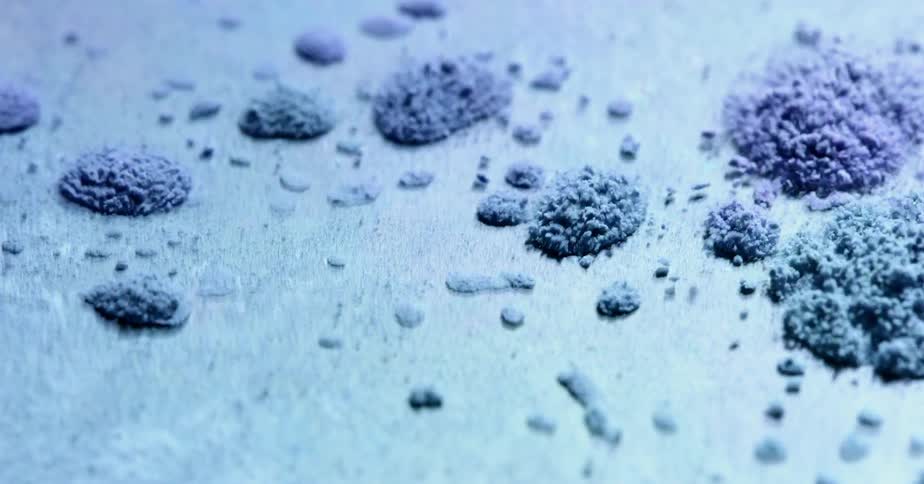 Purple powder vibrating on a blue surface