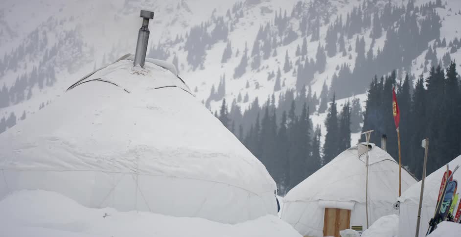 Snow-covered domed buildings sit in a snowy valley