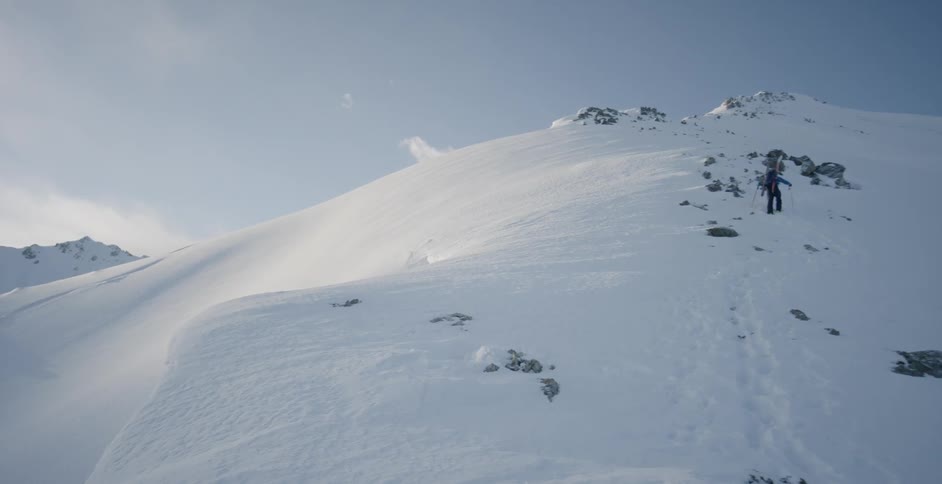 A snow covered rocky mountain slope on a sunny day