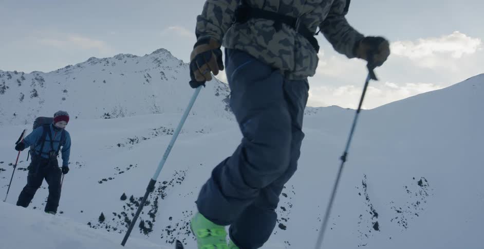 Skiers move up a trail in the mountains