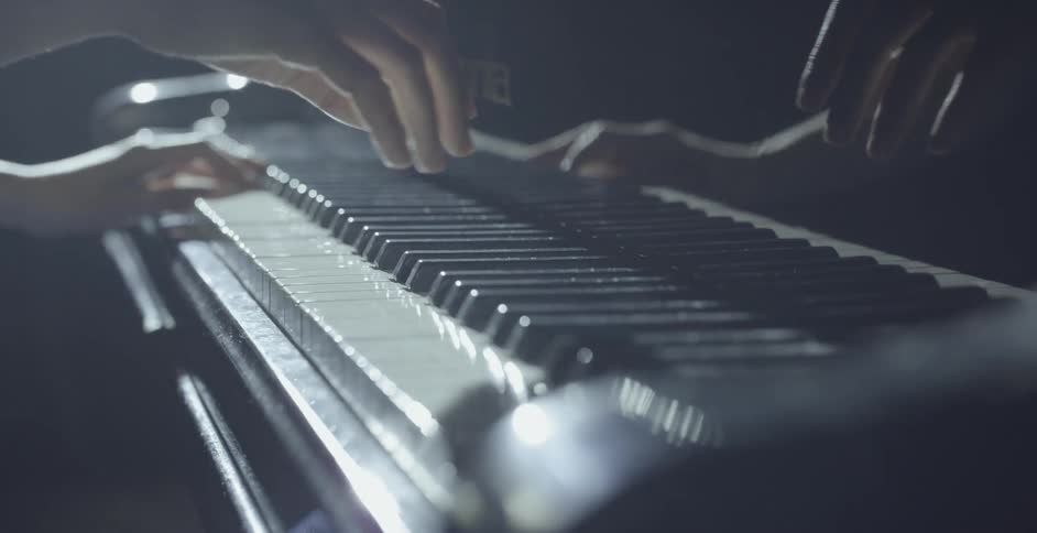 A woman is playing a piano inside on a stage