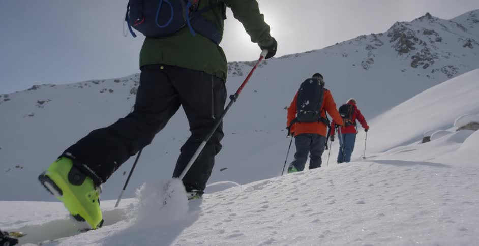 Cross country skiers move up a slope on a sunny day