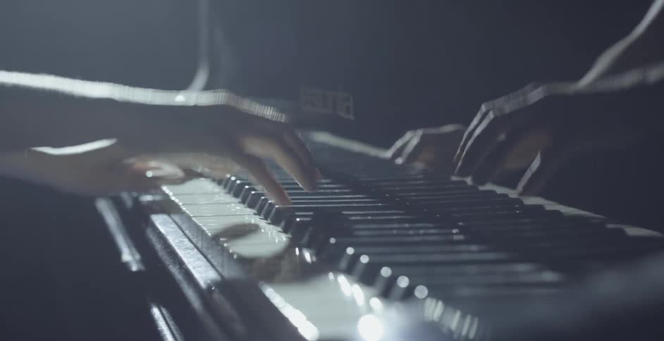 A woman is playing a piano inside on a stage