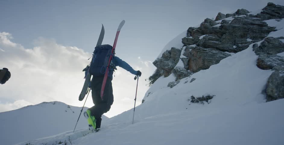 A skier hikes up the hill