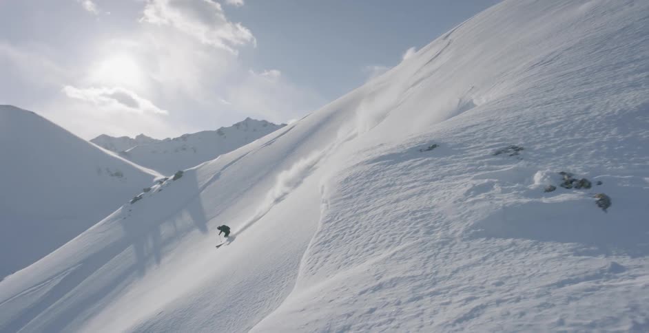 A person is skiing down the steep slope