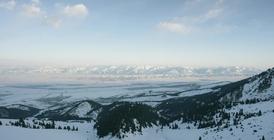 Snow covered land sits under a blue sky