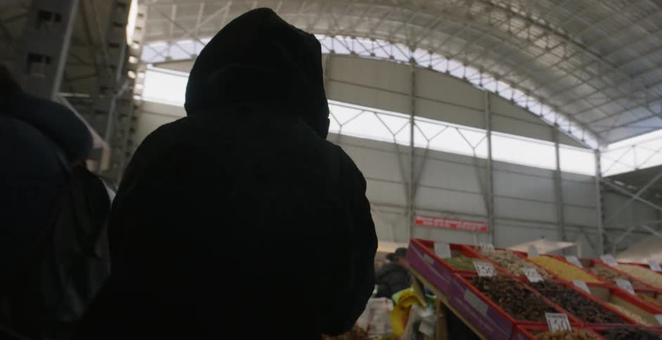 A woman walks through a produce market