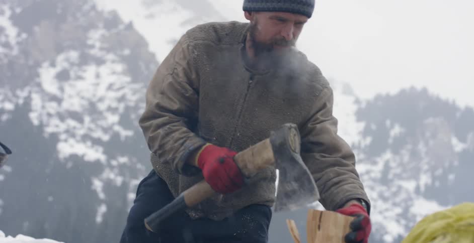A man chops firewood with a hatchet