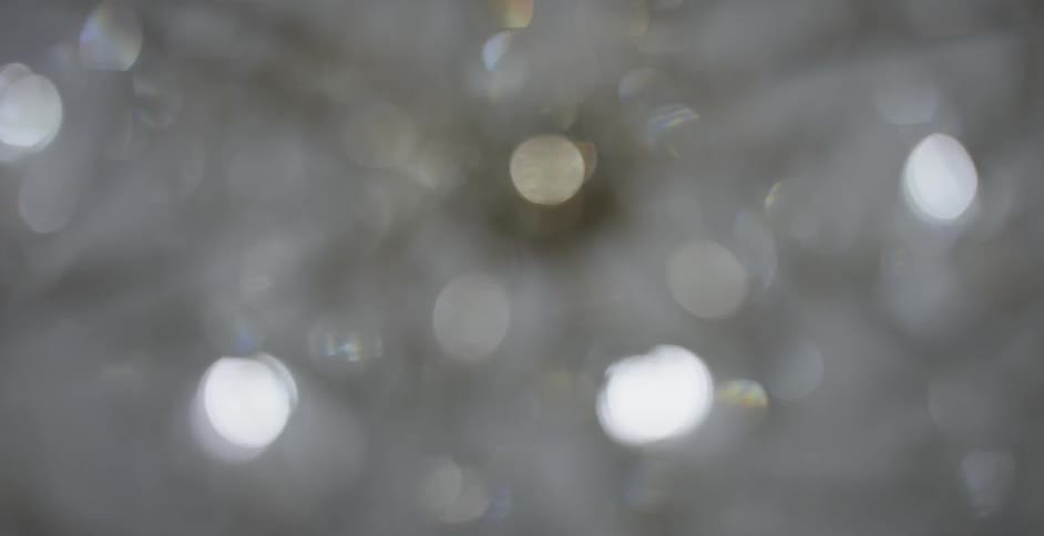 blurry chandelier hangs from the ceiling with light streaming down