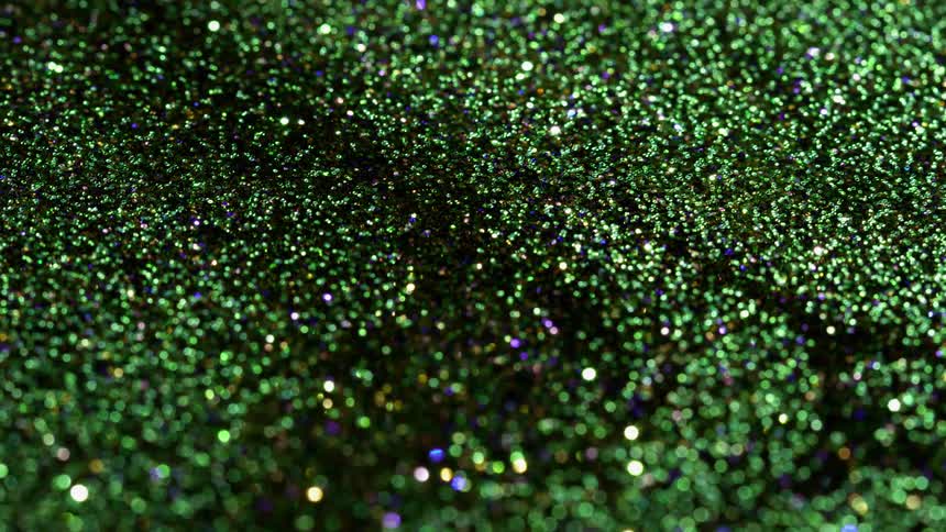 Green and blue glitter rotates and swirls around smoothly