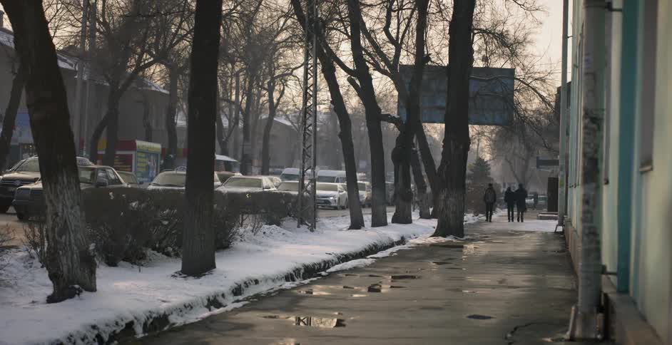 Young kids walk down a city sidewalk