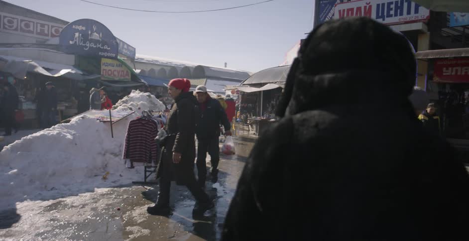 Woman wears a hooded coat as she walks through the market