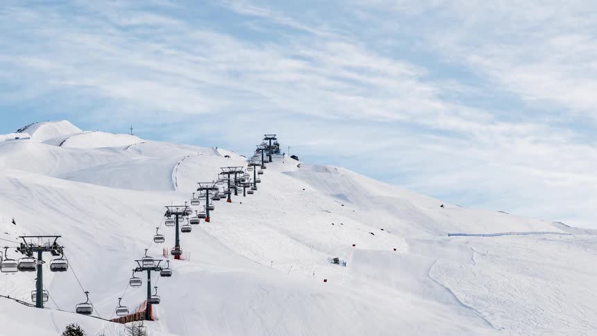 Ski lifts travel up and down a snowy mountainside