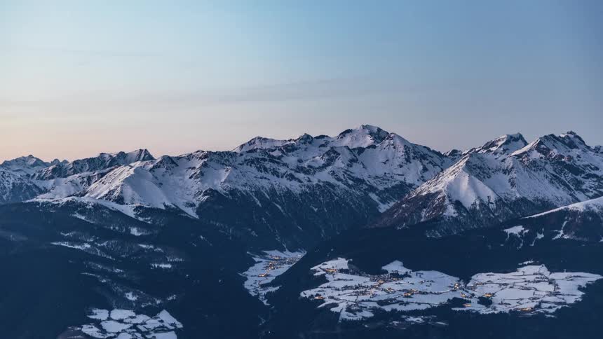 The sun is setting behind the mountain in the distance