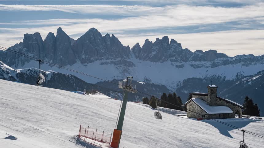 Ski lift carries people up a snowy mountain