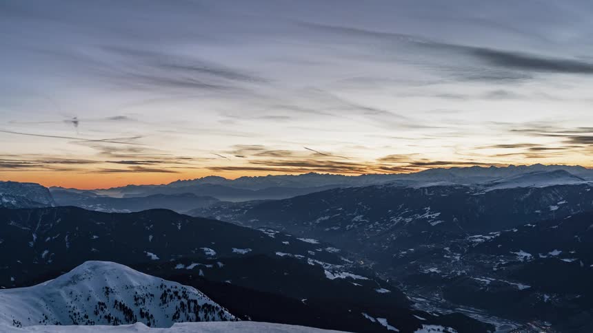 Clouds pass above the snow covered mountains