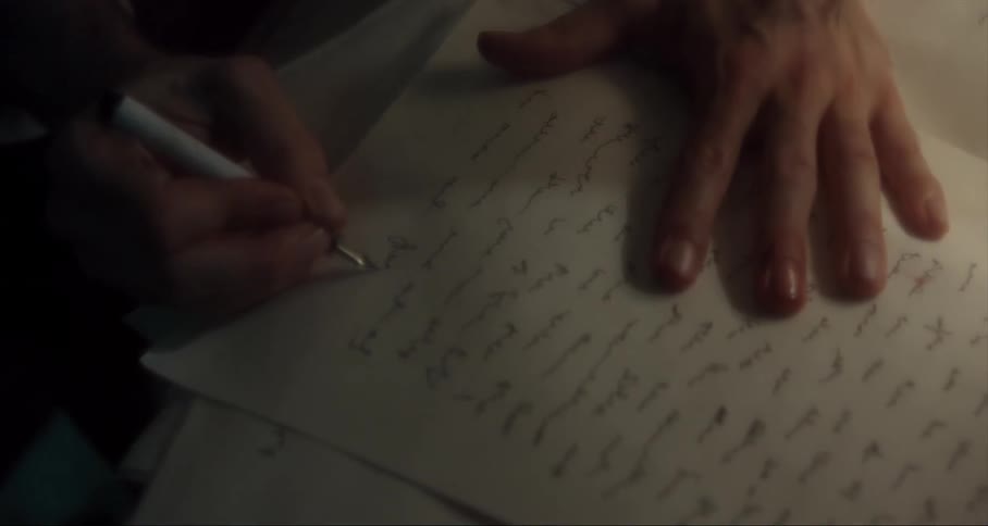 A man writes on a sheet of paper