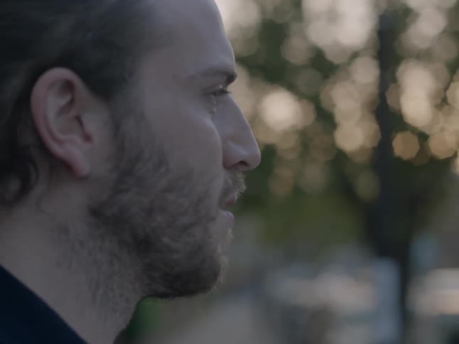 Bearded man blinks as he looks around