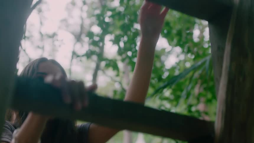 A woman climbs up a wood ladder