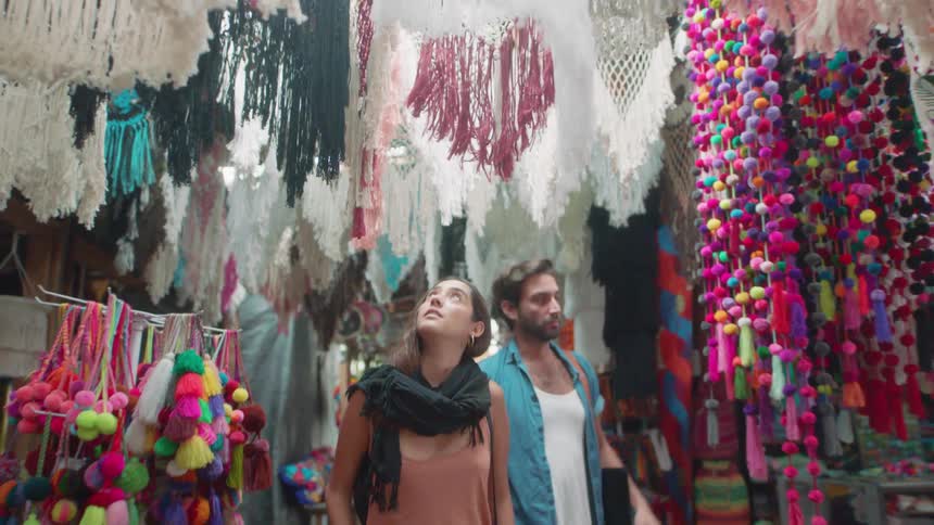 Man and woman look at various crafts at a market