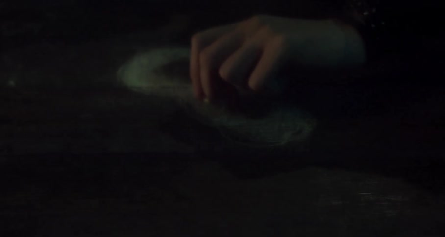A hand repeatedly draws the figure eight