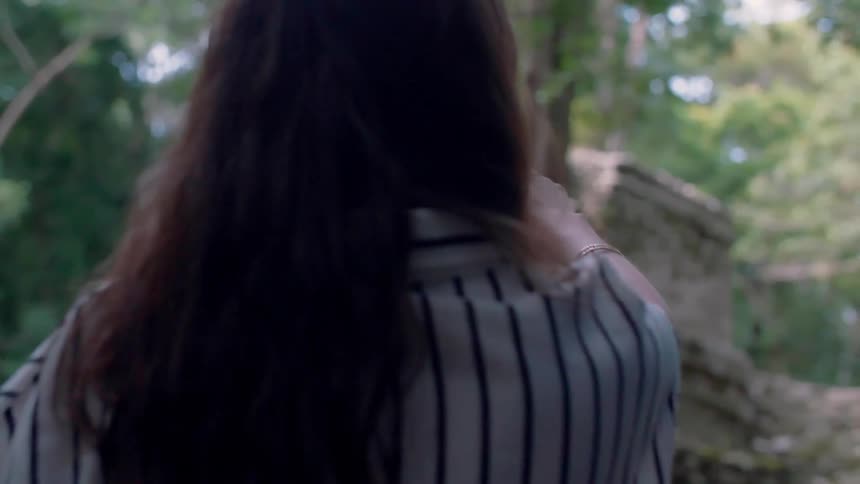 A man and woman talk while looking at ruins