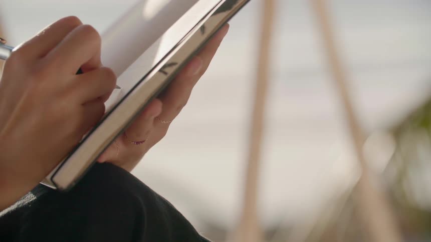 A woman writes in a notebook