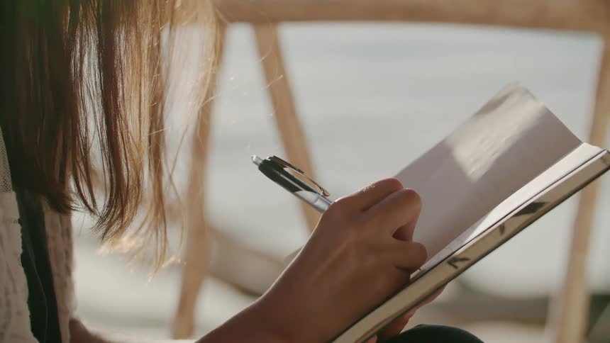 A woman writes in a notebook
