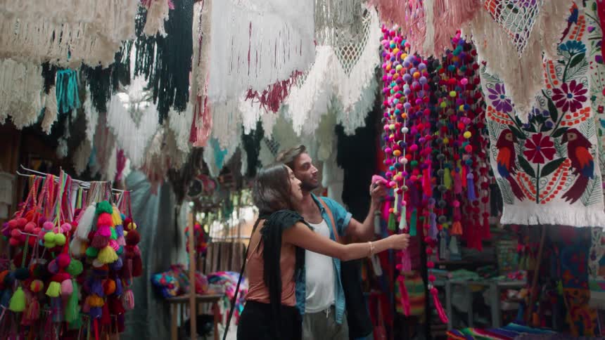 Man and woman look at crafts in a market