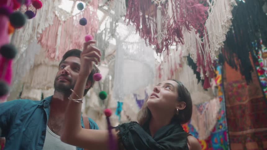 A man and woman looking at a colorful dream catcher