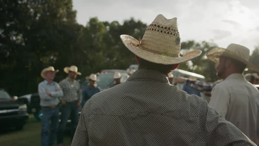 Cowboys gather outside on a sunny day