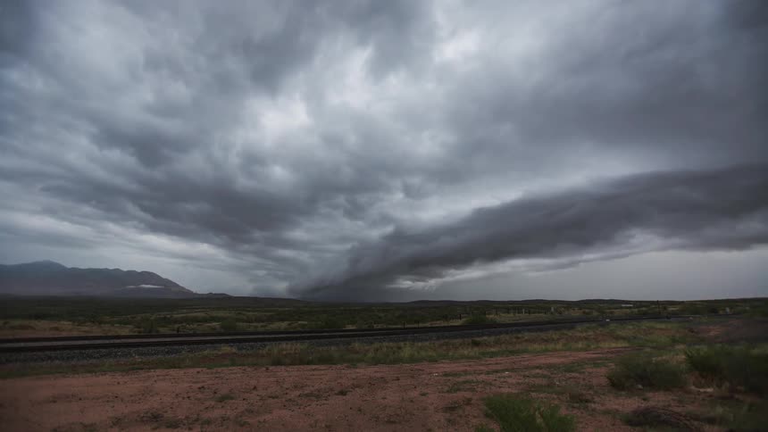 View of clouds swiftly passing over grassy plains