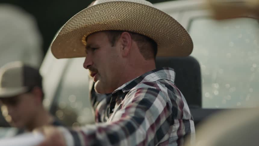 A group of men in cowboy hats have a conversation
