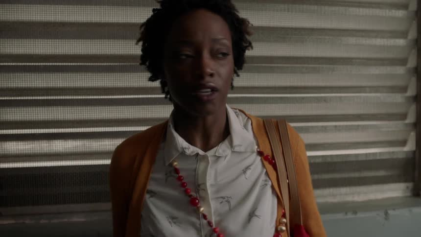 An upset woman walks and cries in a hallway