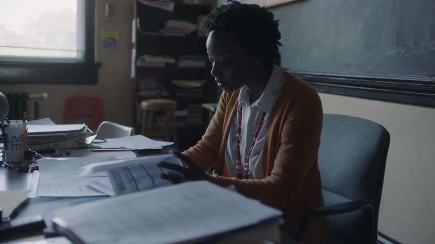 A teacher goes through papers on her desk