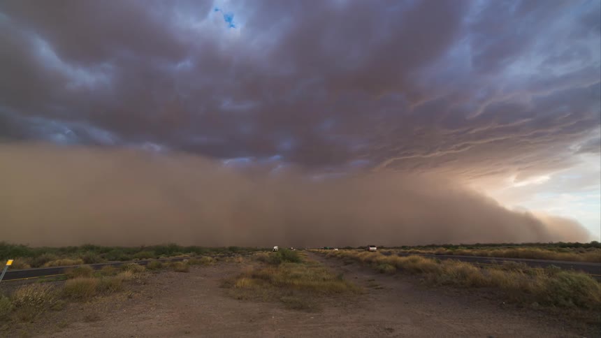 Time lapse of vehicles moving down two separate rods as a storm approaches