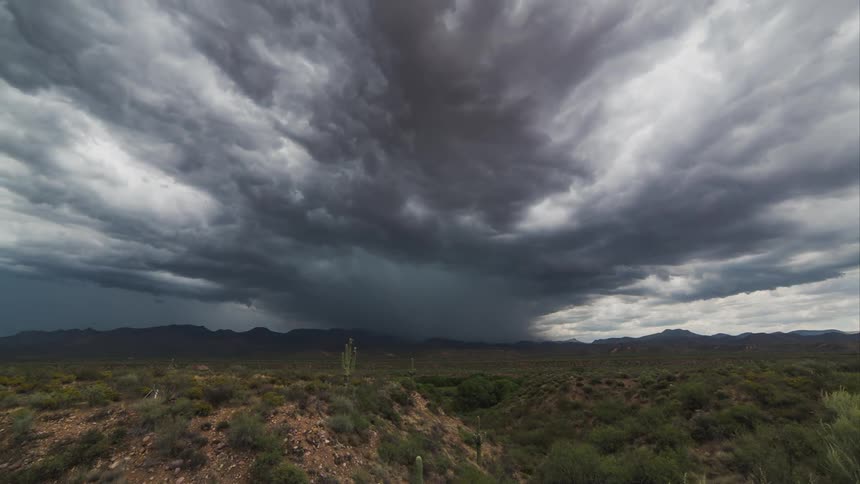 Time lapse on a field with a large tornado forming in the distance