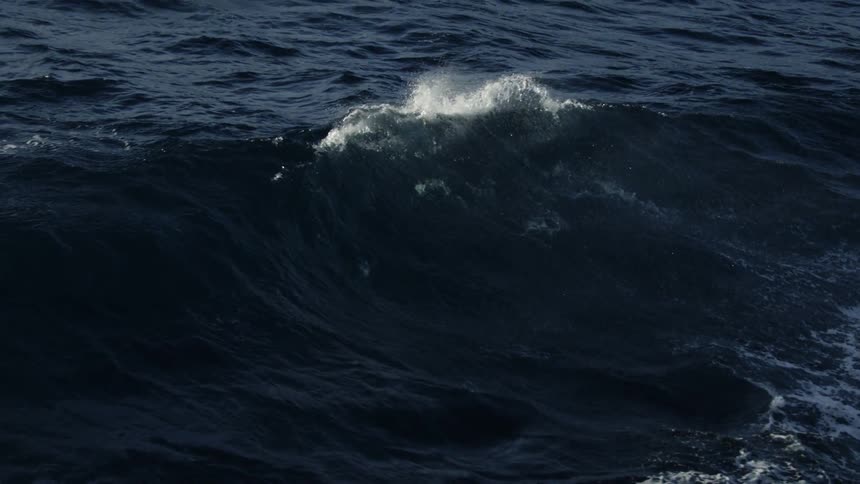 Rough waves crash in the ocean creating moody mist